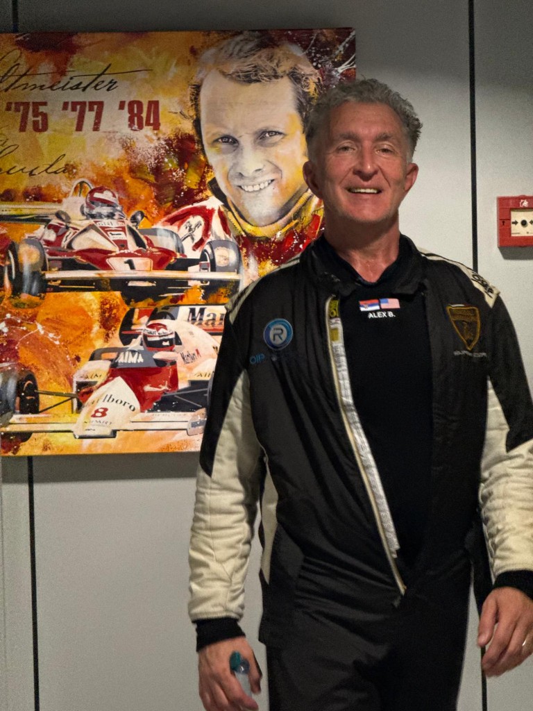 Alex Beatovic in racing suit, portrait with Serbian and US flags on the suit